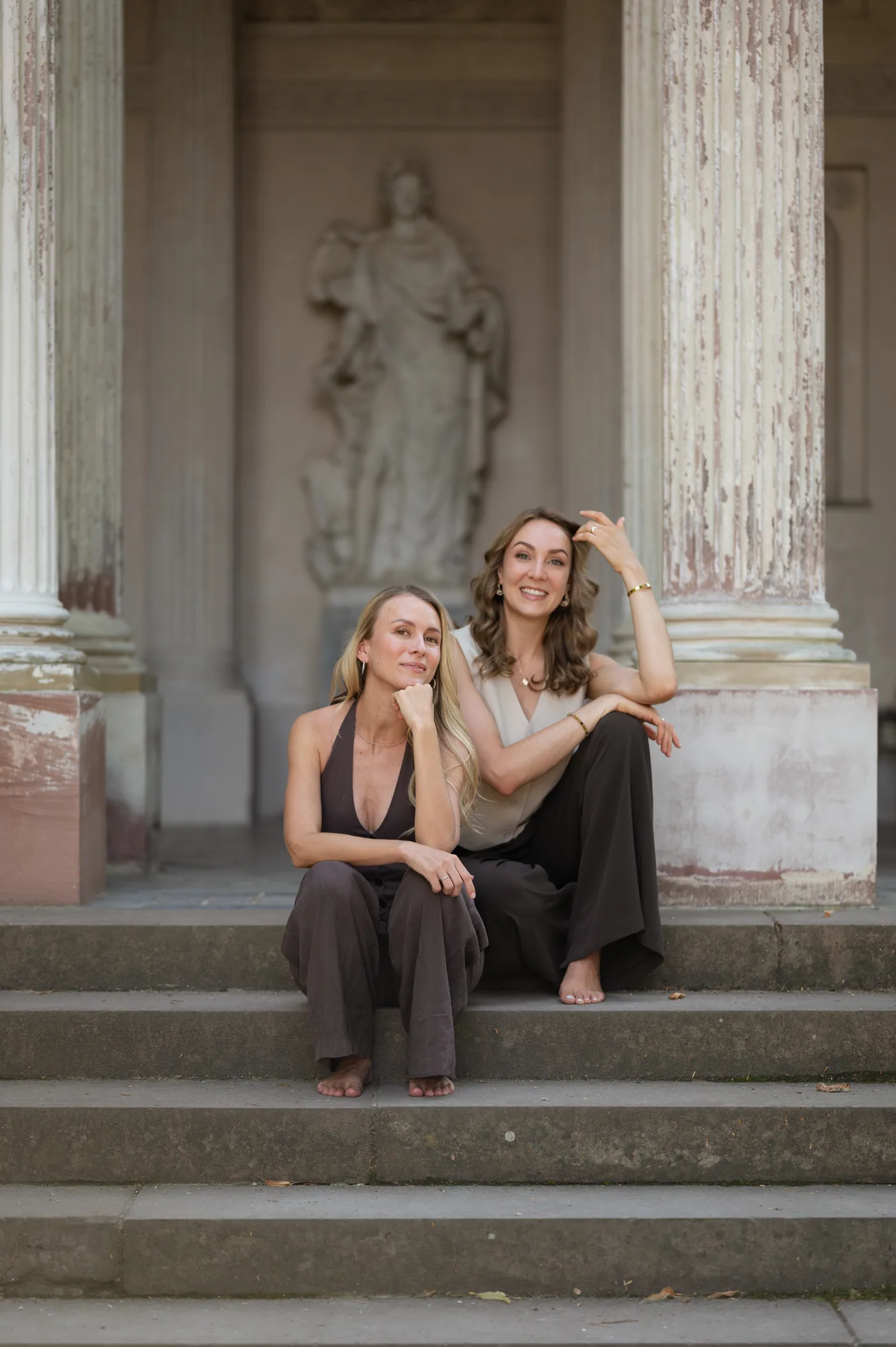 Leah und Regina sitzen gemeinsam auf einer Steintreppe.